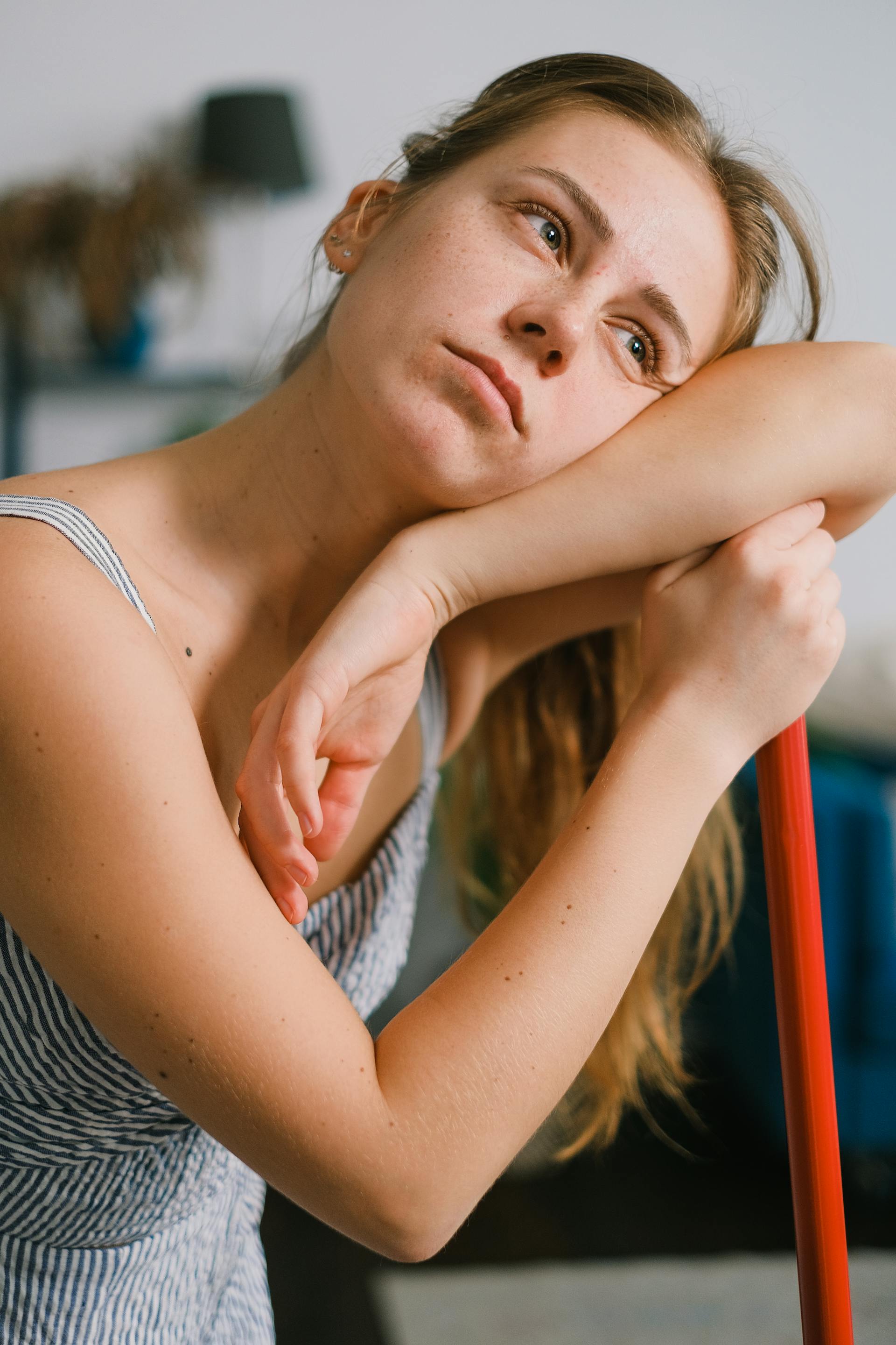 A tired woman leaning on a mop while cleaning | Source: Pexels