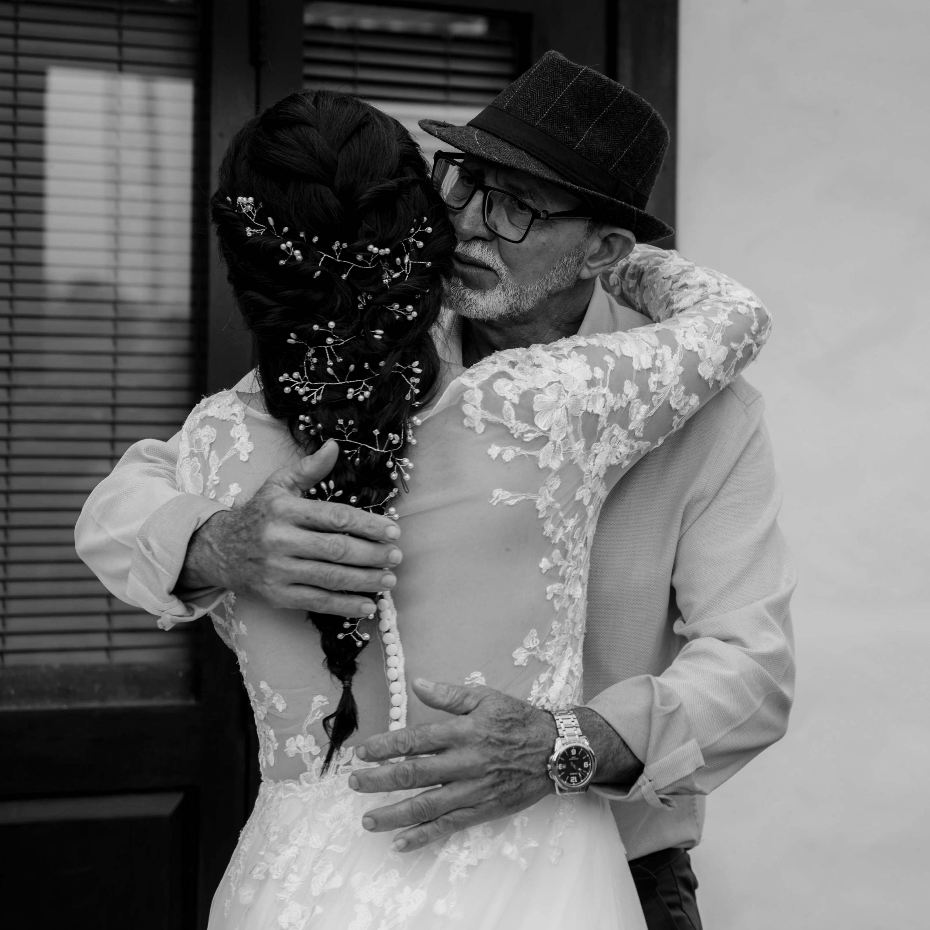 An elderly man hugging a bride | Source: Pexels