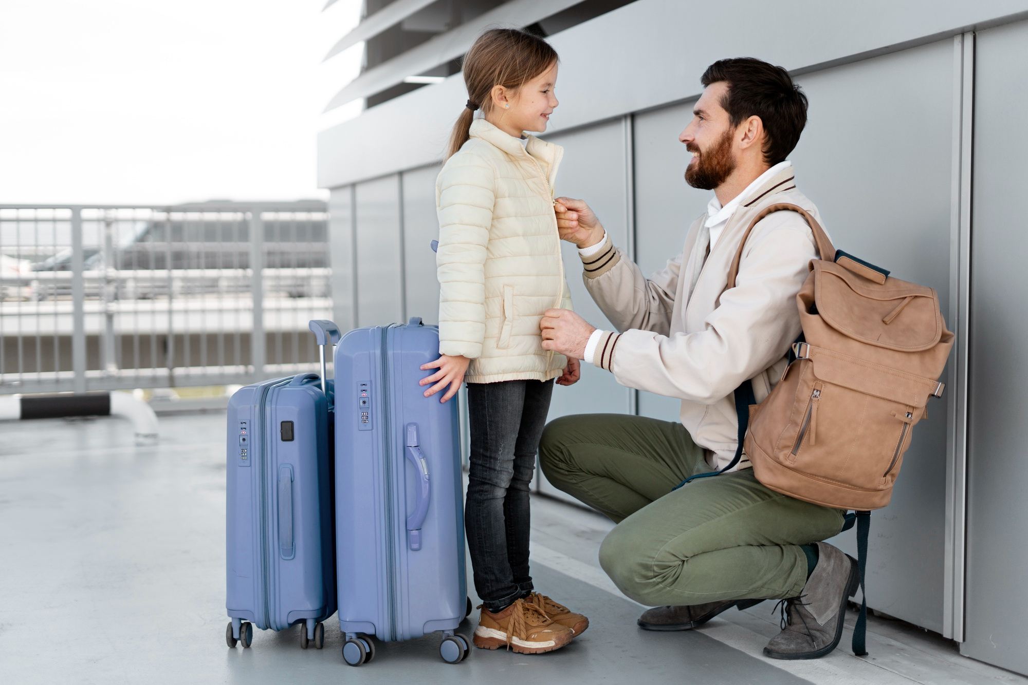 A father and his daughter ready for their trip with luggage on hand