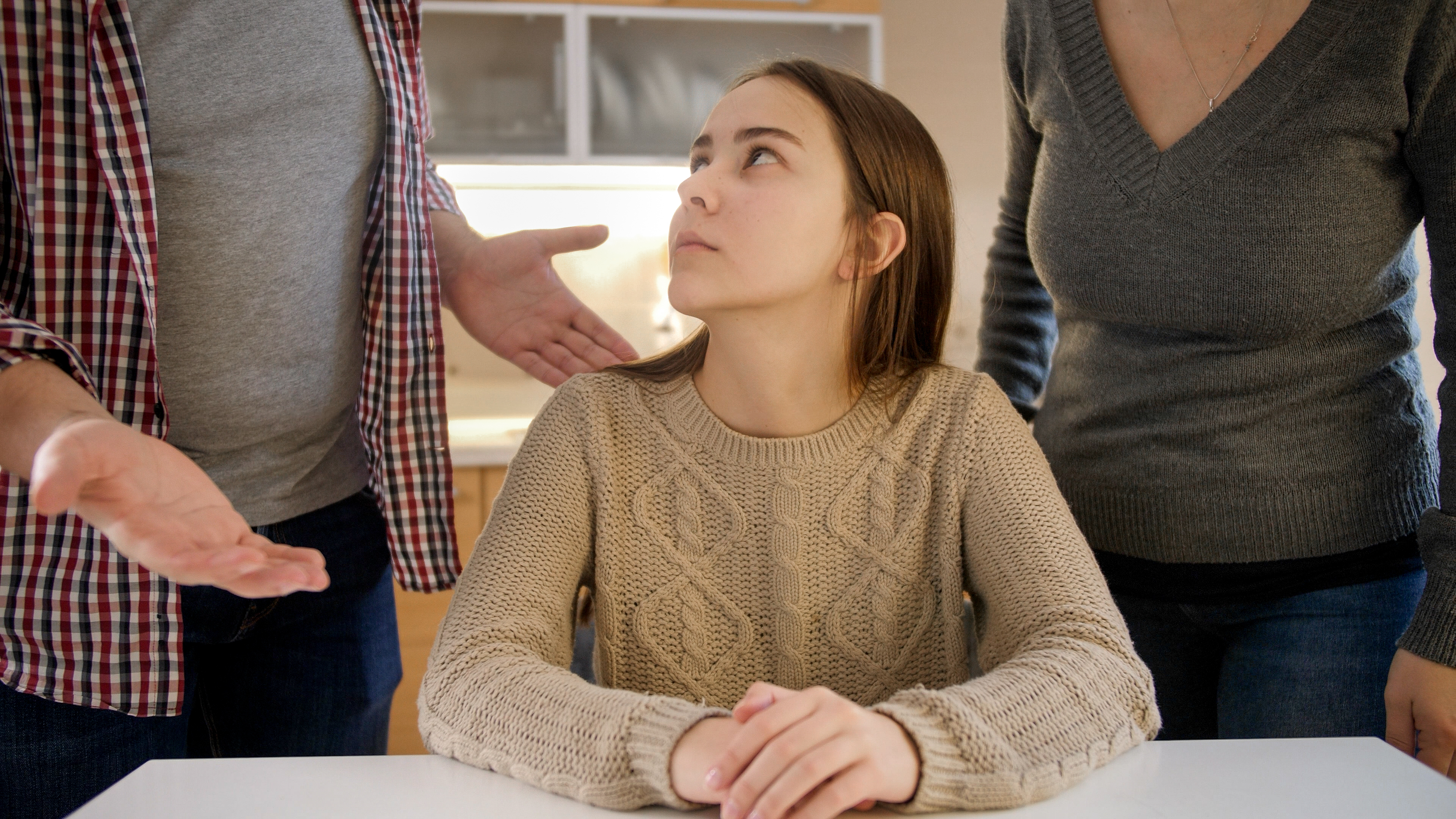 An annoyed adult daughter looking at her parents | Source: Shutterstock