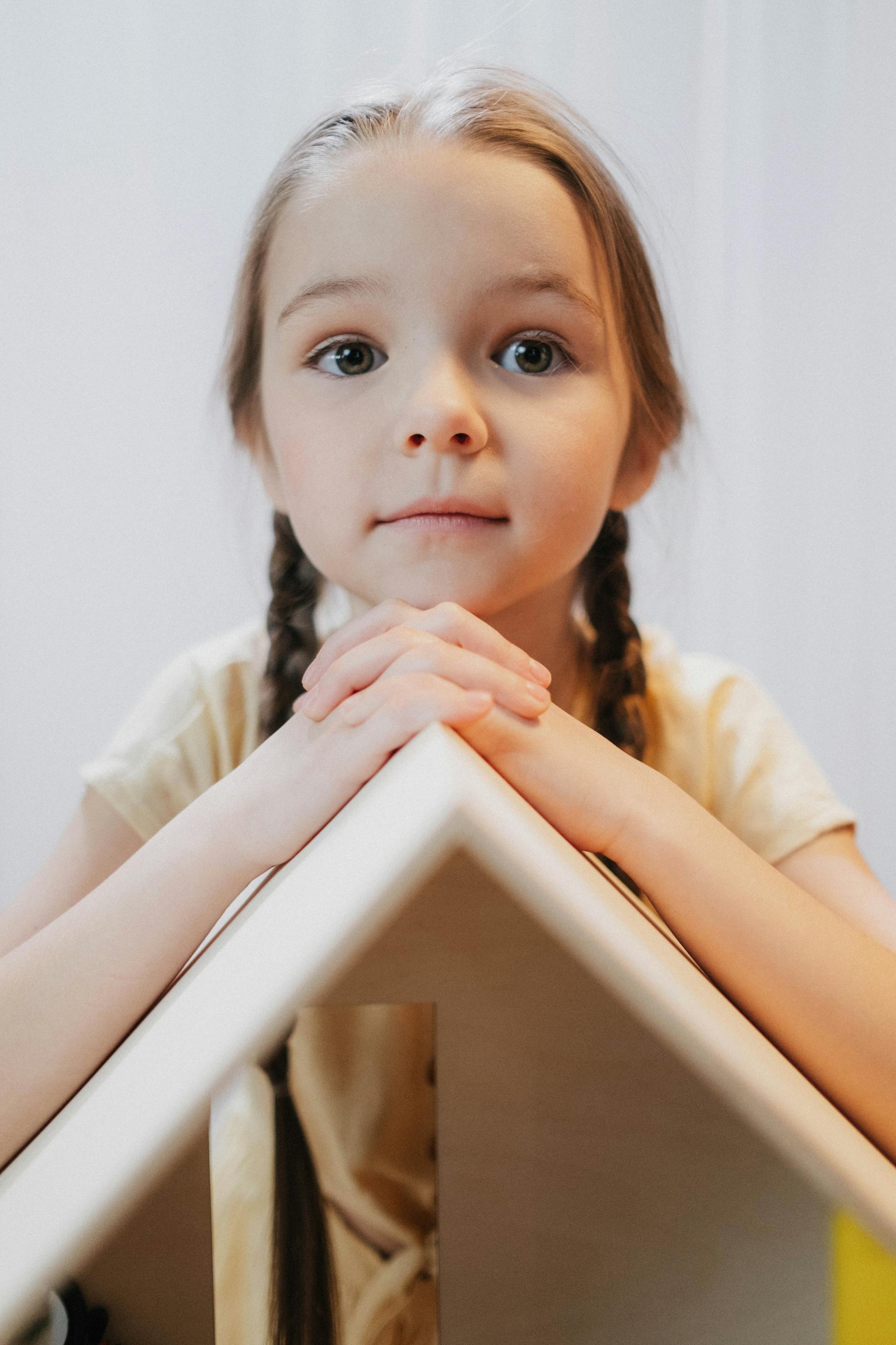 A little girl playing with her dollhouse | Source: Pexels