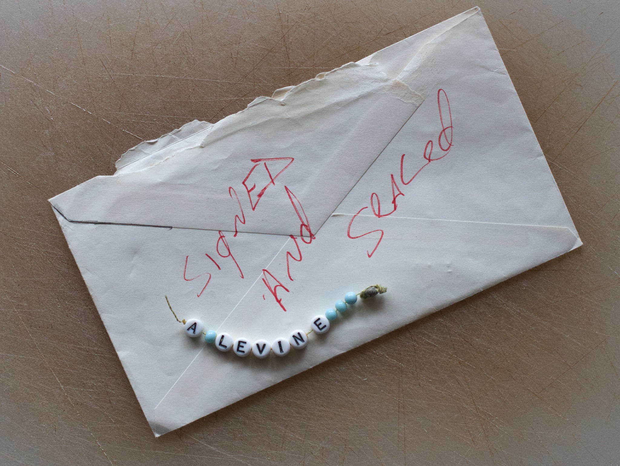 An envelope with a bracelet on top