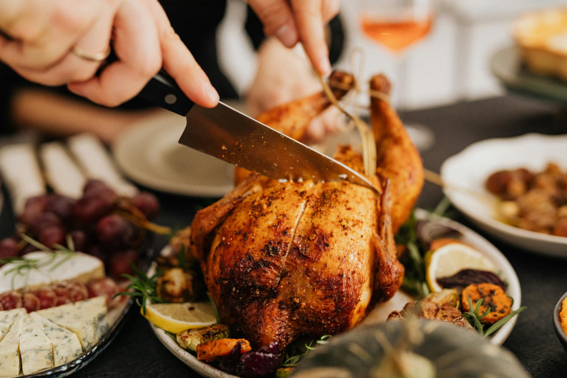 A person cutting a piece of chicken | Source: Pexels