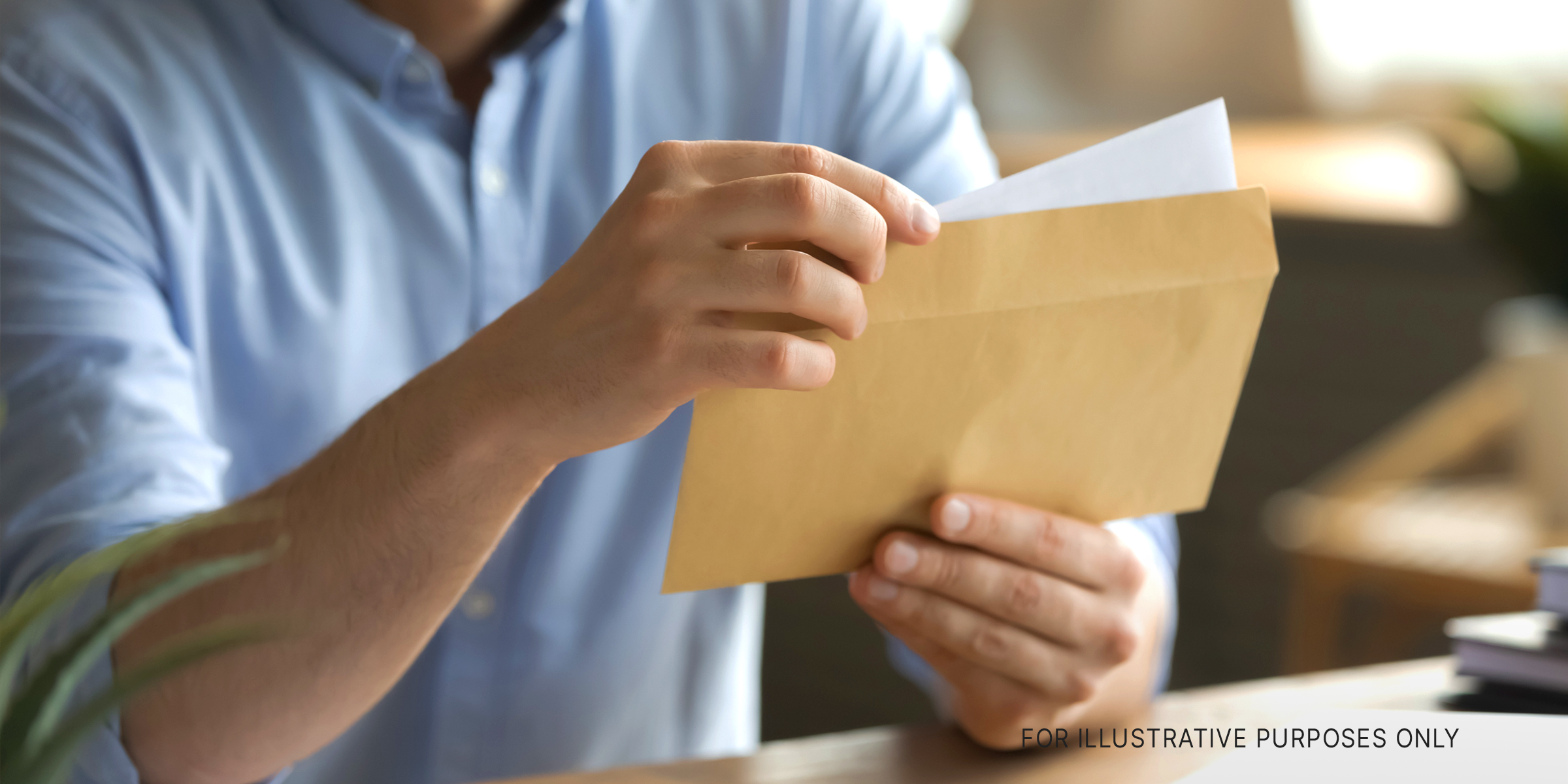 A man opening an envelope and removing a letter