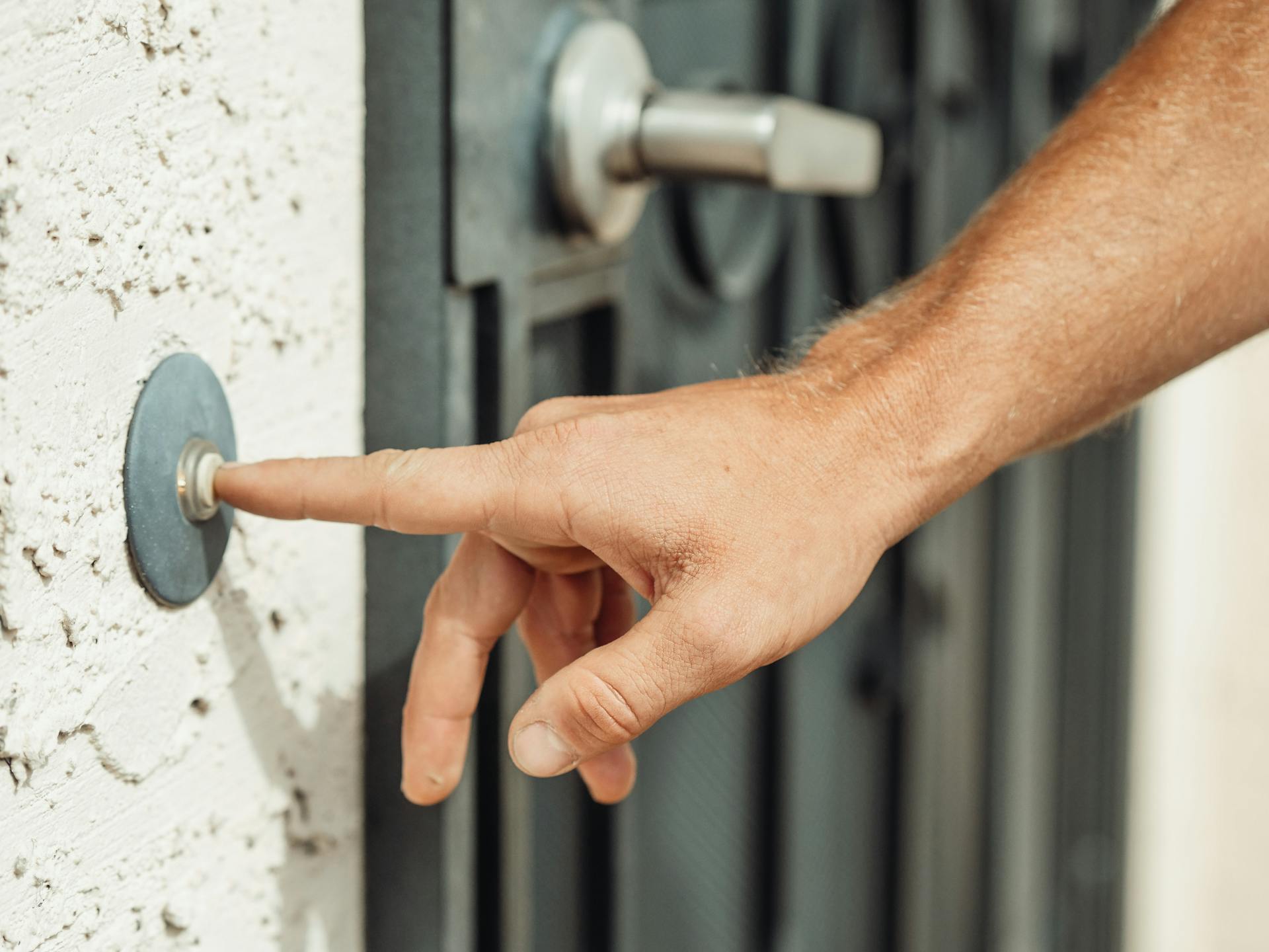 Close-up of a man pressing a buzzer near a door | Source: Pexels