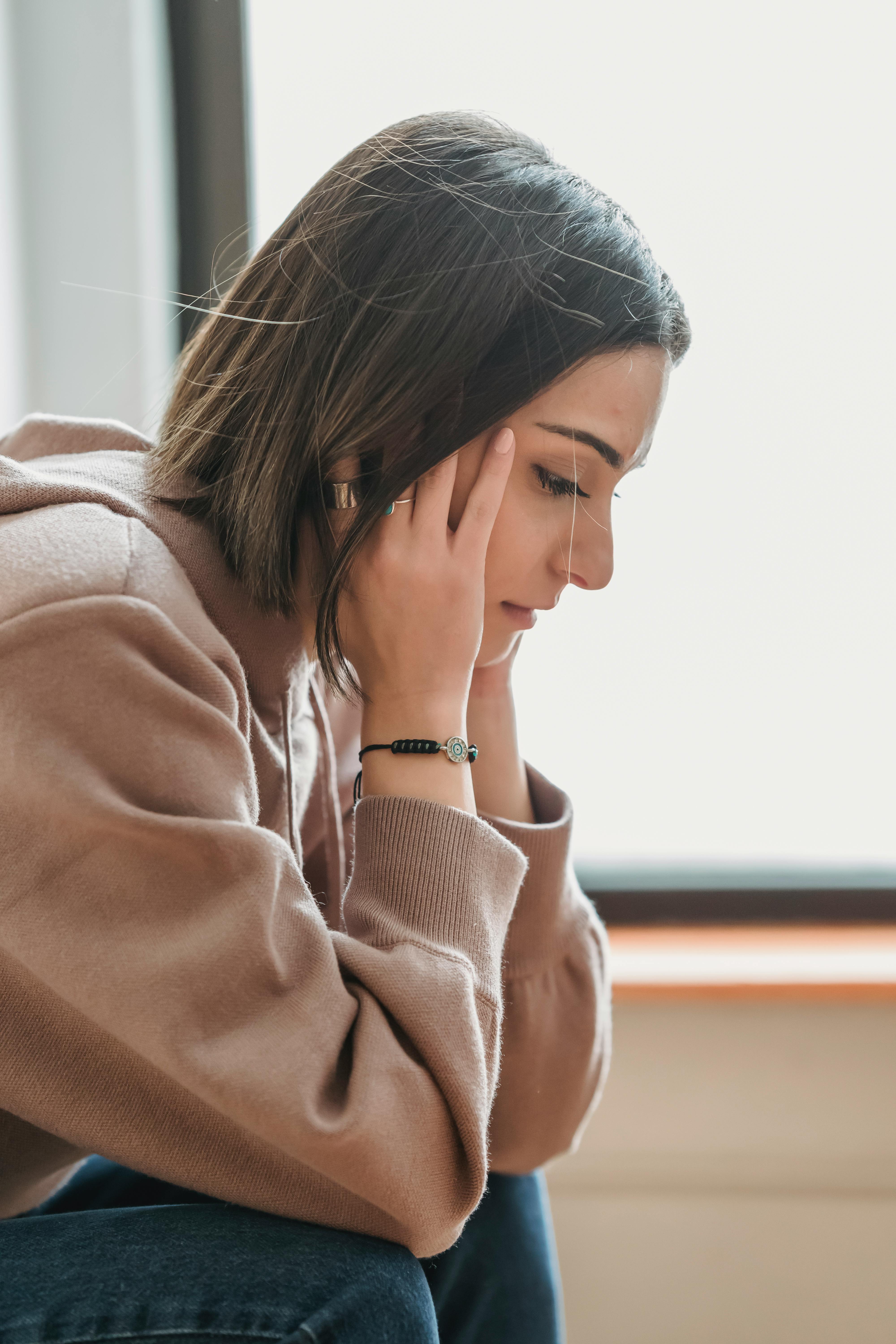 Sad woman with her head in her hands | Source: Pexels