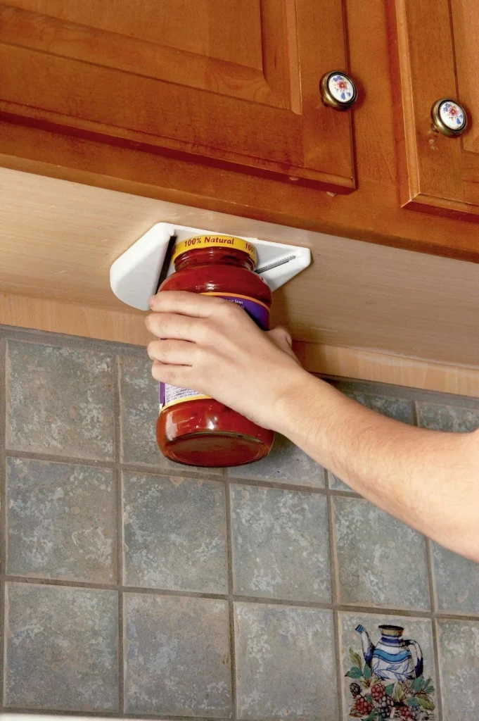 Woman using under-cabinet jar opener